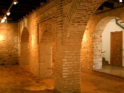 Innenraum mit Backsteinbögen und Säulen im Mudéjar-Stil.