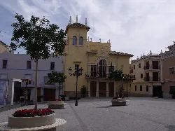 Square with trees, lampposts, and a historic building in Ribarroja del Turia.