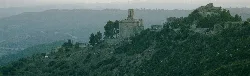 Panoramic view of Rubió with hills and a church on the hilltop.