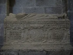 Sepulcro de piedra con inscripciones y escudo en la iglesia de Ledesma.