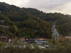 Pozo San Antonio mit Metallstruktur und nahegelegenen Häusern in einer bergigen Landschaft.