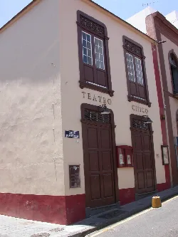 Fachada de un teatro con ventanas y puertas de madera oscuras en Santa Cruz de La Palma.