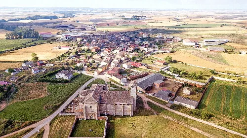 Aerial view of a village with church and farmland.