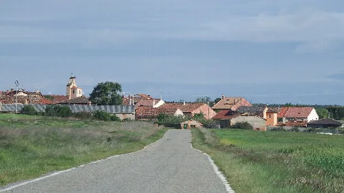 Dirt road with houses and a church in Segovia.