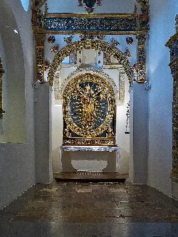Golden altarpiece with Virgin sculpture holding a pomegranate in Osuna's church.