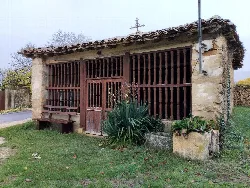 Kleine Stein- und Holzkapelle in Zúñiga, Navarra, mit umliegender Vegetation.