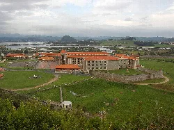 Large stone building with walls and gardens in Santoña.