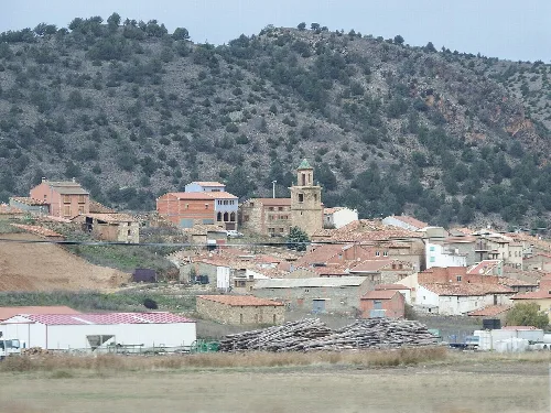 Blick auf Royuela mit Häusern und einer Kirche im Zentrum.