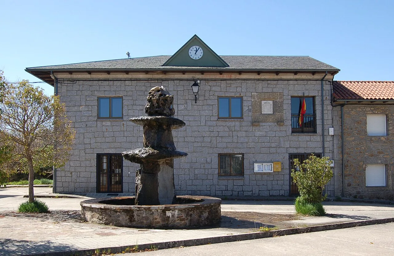 Steinernes Gebäude mit Uhr und Brunnen auf dem Hauptplatz von Cernadilla.