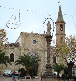 Kirche San Juan mit Turm und Statue in Arjona, Jaén.