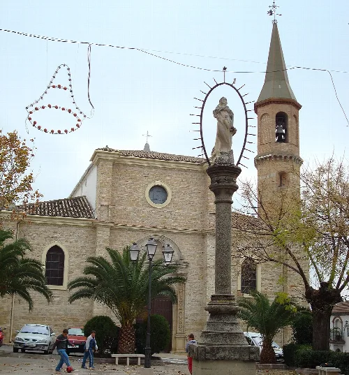 Kirche San Juan mit Turm und Statue in Arjona, Jaén.
