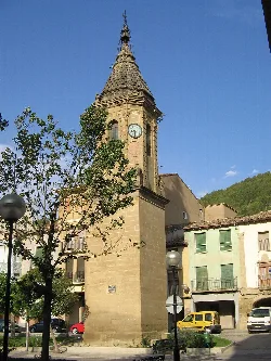Ayerbe clock tower with clock and stone structure in the square.