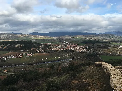 Rural landscape with town, fields, and mountains seen from a fortress.