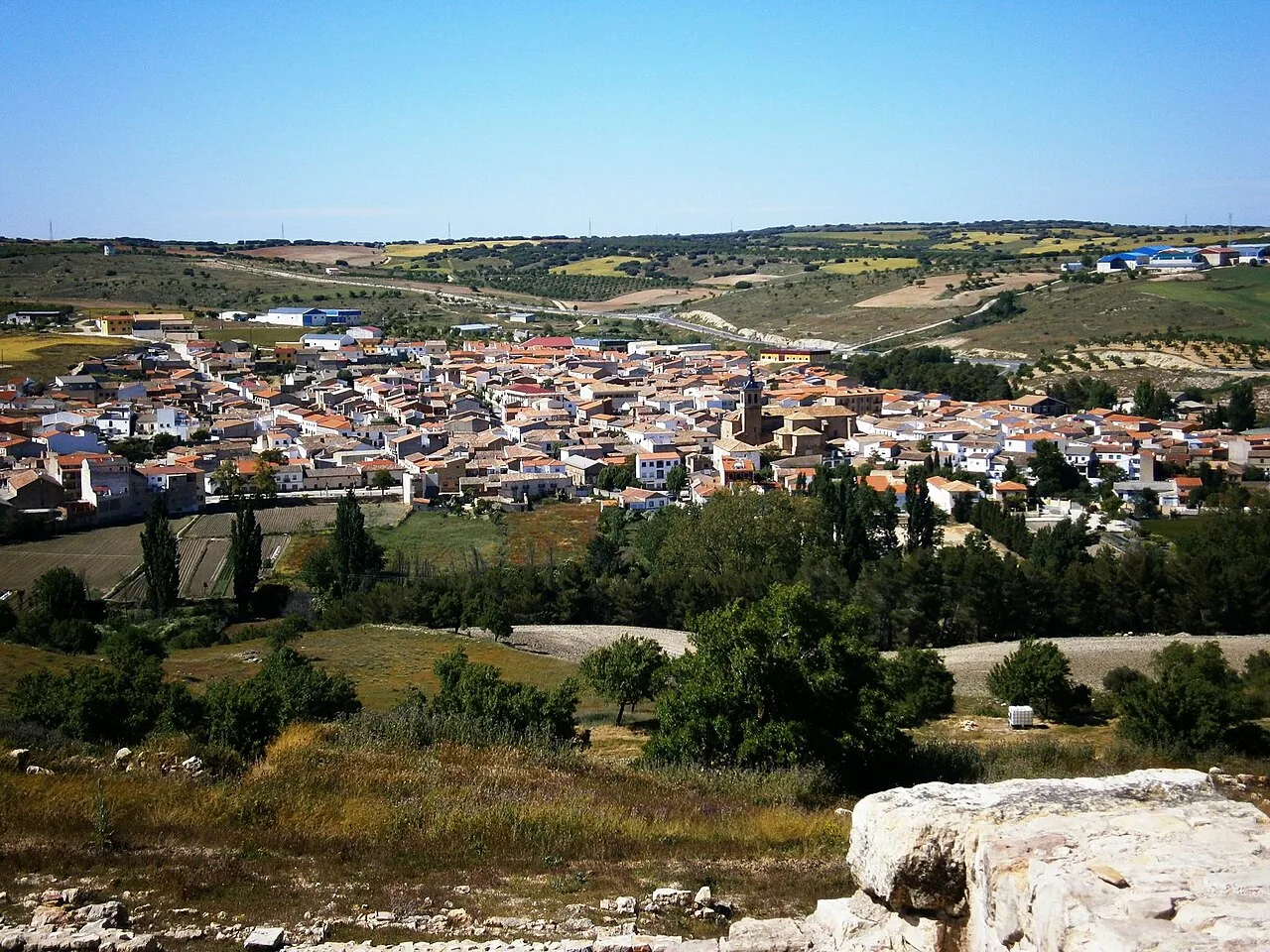 Vista panorámica de Lezuza desde el castillo con casas y campos.