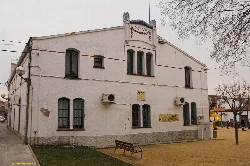 Fachada blanca con ventanas y aire acondicionado en un edificio en un parque.
