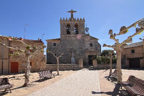 San Mamés Martir church in Fuentecén with trees and benches in the square.