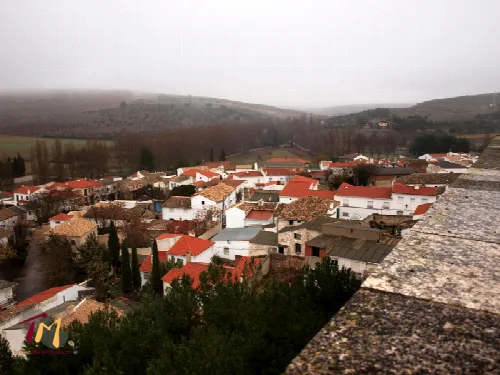Blick auf Häuser mit roten Dächern und Bäumen in Uclés.