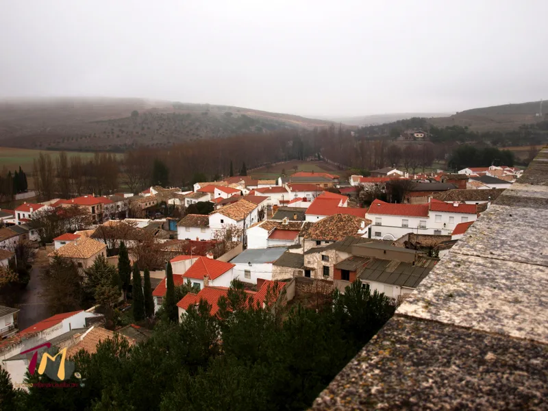 Blick auf Häuser mit roten Dächern und Bäumen in Uclés.