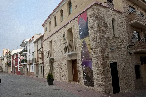 Steinernes Gebäude mit Kunst-Ausstellungsbanner in La Sala, Valencia.