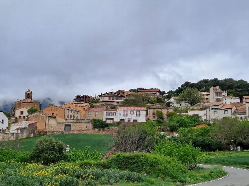 Vista panorámica de Nazar con casas en la colina y vegetación.