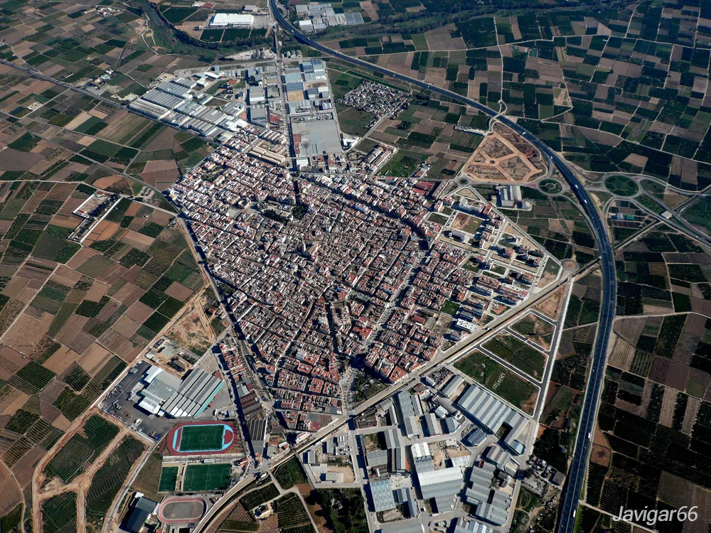 Aerial photo of La Alcudia, Valencia, with streets, buildings, and farmland.