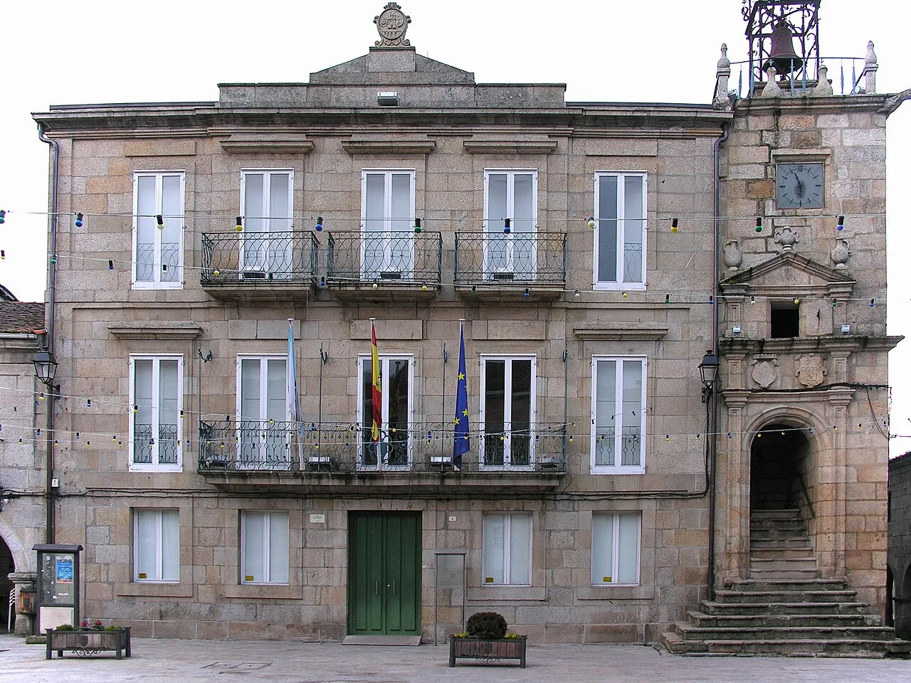 Stone building with flags on the facade in Ribadavia.
