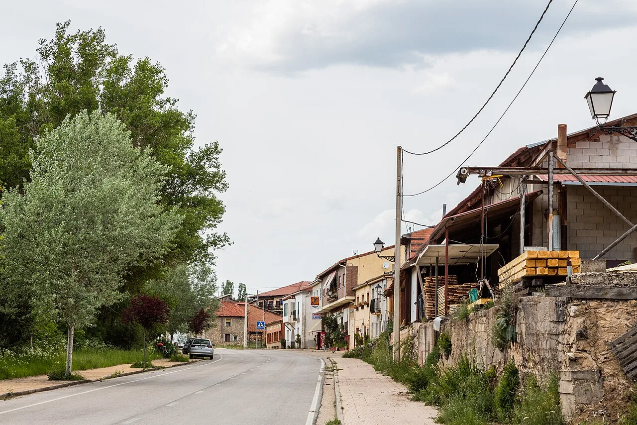 Main street of Casarejos with houses and trees.