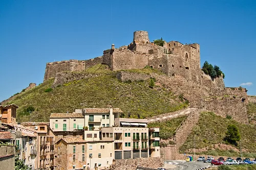 Burg von Cardona auf einem Hügel mit Gebäuden im Vordergrund.