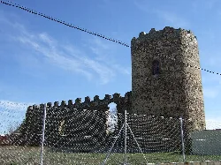 Runder Turm des Schlosses Palacios de la Valduerna mit Mauern und blauem Himmel.