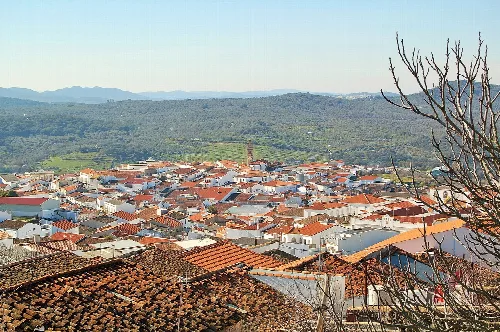 Panoramablick auf Fuentes de León mit Dächern und Bergen in der Ferne