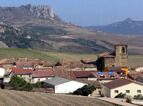 Paisaje de Foncea con casas, iglesia y montañas.