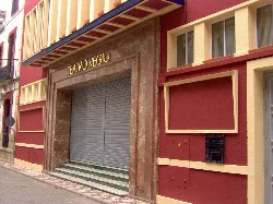 Fassade des Cine Regio Theaters mit geschlossener Eingangstür und Marmordetails.