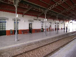 Platform of Puente Genil station with people and benches.