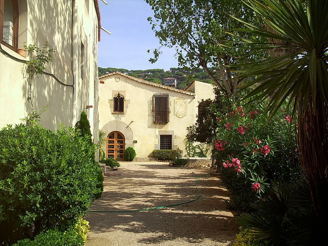 Ansicht des Hauses Can Bartomeu mit Garten und Vegetation.