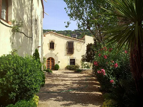 Ansicht des Hauses Can Bartomeu mit Garten und Vegetation.