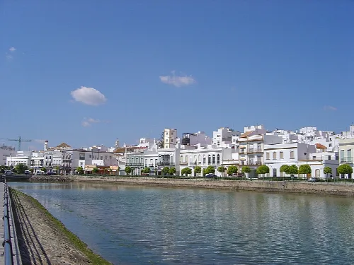 Weiße Häuser am Fluss in Ayamonte, Andalusien, mit blauem Himmel.
