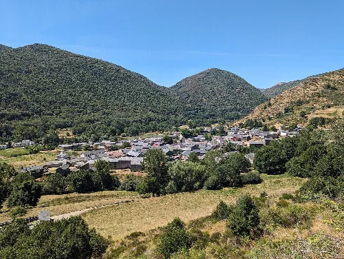 Blick auf ein Dorf vor grünen Bergen in León, Spanien.
