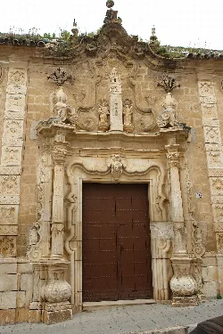 Stone facade with wooden door and decorative stone details in Osuna.