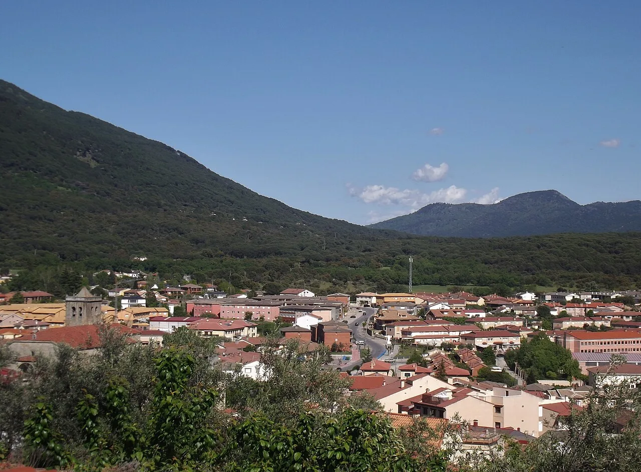 Vista de un pueblo con montañas y colinas en el fondo.