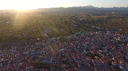 Vista aérea de Moraleja con calles, edificios y campos al atardecer.