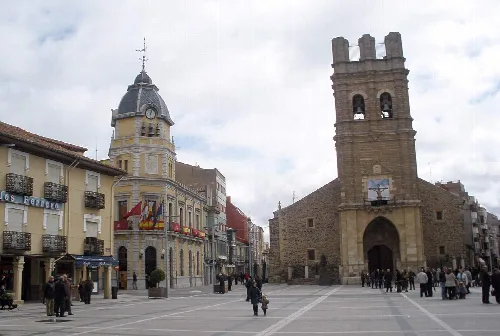 Hauptplatz von La Bañeza mit Gebäuden und einem Turm.