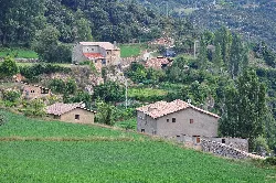 Varios edificios rurales en un paisaje verde en Odèn, Lérida.
