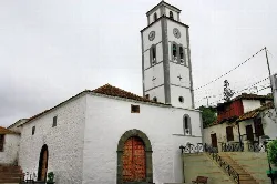 White church with tower and clock in El Tanque, Tenerife.