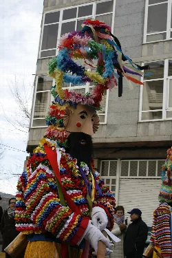 Figur mit alter Maske und buntem Kostüm in Riós, Ourense.