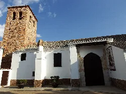 Iglesia con torre de ladrillo y fachada blanca en Ballesteros de Calatrava.