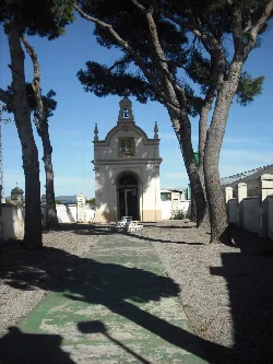 Small white chapel with trees around in Foyos.