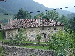 Stone palace with red tile roof and chimneys in a rural setting.