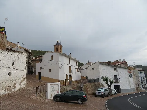 Casas blancas y una iglesia en una calle de Veo, Alcudia de Veo.