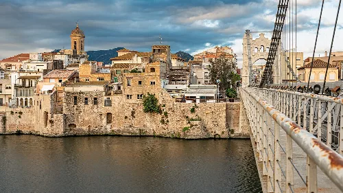 Edificios antiguos y un puente sobre el río en Amposta.