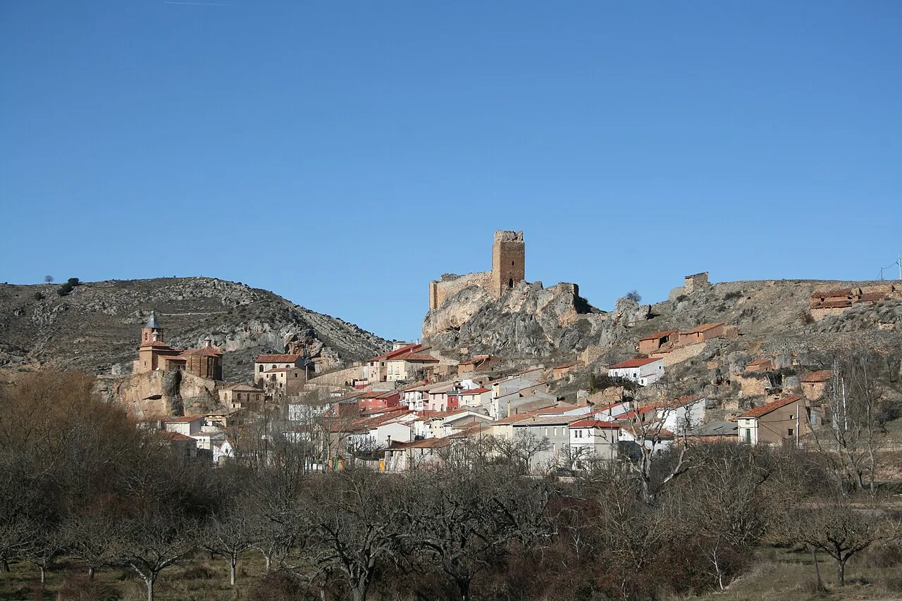 Vista panorámica de Bijuesca con castillo en la cima y casas en la ladera.